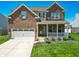 Charming two-story brick home featuring an attached garage and covered front porch at 8644 N Deer Crossing Blvd, McCordsville, IN 46055