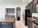 Open kitchen featuring dark cabinets, stainless appliances, granite counters, and white marble floors at 8644 N Deer Crossing Blvd, McCordsville, IN 46055