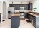Well-lit kitchen with island, dark cabinets, stainless steel appliances and marbled tile flooring at 8644 N Deer Crossing Blvd, McCordsville, IN 46055