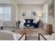 Cozy living room with a plush blue couch, decorative pillows, a modern coffee table, and hardwood flooring at 8644 N Deer Crossing Blvd, McCordsville, IN 46055