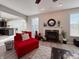 Comfortable living room featuring a fireplace, large windows, and a red couch at 8644 N Deer Crossing Blvd, McCordsville, IN 46055