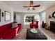 Inviting living room features an open floorplan to the kitchen, hardwood flooring, and a stylish red couch at 8644 N Deer Crossing Blvd, McCordsville, IN 46055