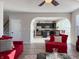 Bright living room showcasing hardwood floors, neutral walls, red couches, and an open floorplan to the kitchen at 8644 N Deer Crossing Blvd, McCordsville, IN 46055