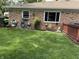Lush backyard featuring brick house, well-manicured lawn, and outdoor faucet, perfect for gardening and relaxation at 9521 Gemini Dr, Indianapolis, IN 46229