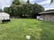Expansive backyard with lush green grass, mature trees, and functional storage shed offers serene outdoor space at 9521 Gemini Dr, Indianapolis, IN 46229