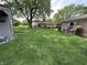 Spacious backyard with green grass, mature tree, and a charming single-Gathering home at 9521 Gemini Dr, Indianapolis, IN 46229