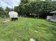 Large, well-manicured backyard featuring lush lawn, mature trees, and a shed, perfect for outdoor activities at 9521 Gemini Dr, Indianapolis, IN 46229