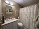 Bathroom featuring a well-lit vanity, toilet, and shower with decorative curtain at 9521 Gemini Dr, Indianapolis, IN 46229