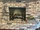 Brick fireplace with metal screen and andirons, adding warmth and charm to the living space at 9521 Gemini Dr, Indianapolis, IN 46229
