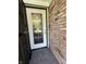Close-up of a home's exterior featuring a decorative glass front door set in a brick facade at 9521 Gemini Dr, Indianapolis, IN 46229