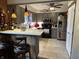 Modern kitchen with gray cabinets, stainless steel refrigerator, bar seating, and tile flooring at 9521 Gemini Dr, Indianapolis, IN 46229