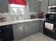 Gray kitchen with stainless steel appliances, mosaic backsplash, and a red coffee maker at 9521 Gemini Dr, Indianapolis, IN 46229