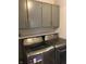 Modern laundry room features gray cabinets and stainless steel washer and dryer at 9521 Gemini Dr, Indianapolis, IN 46229