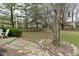 Landscaped back yard with mature trees, stone borders, and a patio area at 10764 Northhampton Dr, Fishers, IN 46038