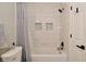 Updated bathroom with white marble-look tile, recessed shower shelves, and black hardware at 10764 Northhampton Dr, Fishers, IN 46038