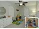 Shared bedroom with two cribs, ceiling fan, and ample play space at 10764 Northhampton Dr, Fishers, IN 46038