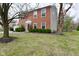 Two-story brick home showcasing the front yard with mature trees at 10764 Northhampton Dr, Fishers, IN 46038