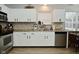 Well-lit kitchen featuring granite countertops, white cabinets, and modern stainless steel appliances at 10764 Northhampton Dr, Fishers, IN 46038