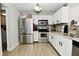 Spacious kitchen with stainless steel appliances, white cabinets, and a view of the dining area at 10764 Northhampton Dr, Fishers, IN 46038