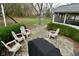 Backyard patio area with stone pavers, outdoor chairs, and a grill for outdoor enjoyment at 10764 Northhampton Dr, Fishers, IN 46038