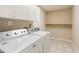 Well-equipped laundry area with white washer and dryer, storage cabinets and neutral wall color at 11438 Winding Wood Dr, Indianapolis, IN 46235