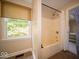Clean bathroom featuring a modern shower and tub combination, window with natural light, and tiled flooring at 11536 Woods Bay Ln, Indianapolis, IN 46236