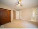 Bright bedroom with neutral tones, a ceiling fan, soft carpeting, and ample space with a large closet at 11536 Woods Bay Ln, Indianapolis, IN 46236