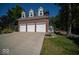 Three-car garage with white doors and brick facade at 11536 Woods Bay Ln, Indianapolis, IN 46236