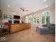Open living room featuring tile floors, a fireplace, built-ins, and arched windows at 11536 Woods Bay Ln, Indianapolis, IN 46236