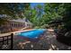 Backyard swimming pool with brick trim, lounge furniture, and mature trees at 11536 Woods Bay Ln, Indianapolis, IN 46236
