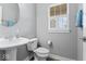 Powder room features pedestal sink, toilet and window with plantation shutters at 12052 Northface Dr, Noblesville, IN 46060