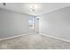 A bright bedroom with plush carpeting, white trim, and a stylish light fixture at 12052 Northface Dr, Noblesville, IN 46060