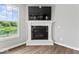 Bright living room features a modern fireplace with a TV above and a large window with a beautiful view at 12052 Northface Dr, Noblesville, IN 46060