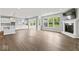 Open-concept living room showcases fireplace, large windows, hardwood floors, and flows into the bright kitchen at 12052 Northface Dr, Noblesville, IN 46060