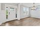 Bright living room featuring lots of natural light, wood-look floors, and modern light fixture at 12052 Northface Dr, Noblesville, IN 46060