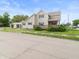 View of a two-story home with tan siding, dark shutters, a front porch and a three-car garage at 1225 S Monroe St, Muncie, IN 47302