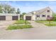 View of a two-story home with tan siding and three garages with dark brown doors at 1225 S Monroe St, Muncie, IN 47302