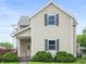 Charming two-story home with tan siding, dark shutters and a covered front porch at 1225 S Monroe St, Muncie, IN 47302