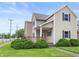 Two-story home with tan siding, dark shutters, a front porch, and lawn at 1225 S Monroe St, Muncie, IN 47302
