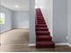 Hallway view with carpeted stairs and hardwood-style floors leading to another room at 1225 S Monroe St, Muncie, IN 47302