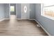 Living room with gray walls, light floors and a white front door with an oval window at 1225 S Monroe St, Muncie, IN 47302
