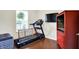 A multi-purpose room featuring a treadmill, TV, and dark-toned hard wood flooring at 1286 Brookdale Ct, Franklin, IN 46131