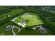 Wide aerial perspective of an estate with surrounding acreage, horse area, and established landscaping at 12945 E 100 N, Columbus, IN 47203