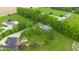 Aerial view showcases a home with an expansive backyard, wooden deck, mature trees, and lush lawn at 12945 E 100 N, Columbus, IN 47203