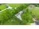 Aerial view featuring a home with a long driveway, detached garage, outbuilding, and mature landscaping at 12945 E 100 N, Columbus, IN 47203