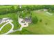Beautiful home with a circular driveway and lush landscaping, surrounded by mature trees and green space at 12945 E 100 N, Columbus, IN 47203