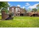 Expansive brick home with manicured lawn, tiered deck, and brick wall, offering luxury outdoor living at 12945 E 100 N, Columbus, IN 47203