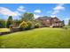 Expansive backyard featuring a brick home, manicured lawn, brick wall, and deck, ideal for outdoor enjoyment at 12945 E 100 N, Columbus, IN 47203