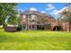 Stunning brick home with lush lawn, multi-level deck, and brick wall, creating a private outdoor retreat at 12945 E 100 N, Columbus, IN 47203