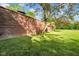 Brick wall with grassy lawn and natural shade, adds privacy to this property's scenic backyard at 12945 E 100 N, Columbus, IN 47203